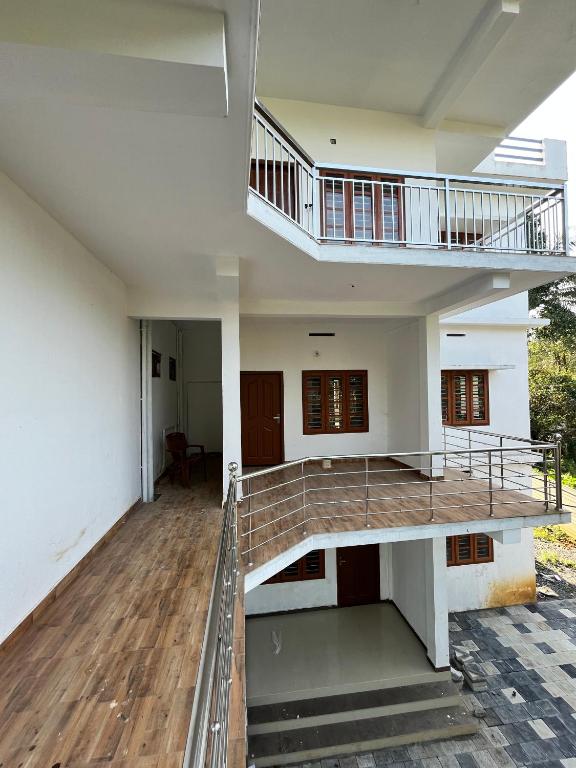 a view of a house with a staircase at Wayanad Biriyomz Residency, Kalpatta, Low Cost Rooms and Deluxe Apartment in Kalpetta
