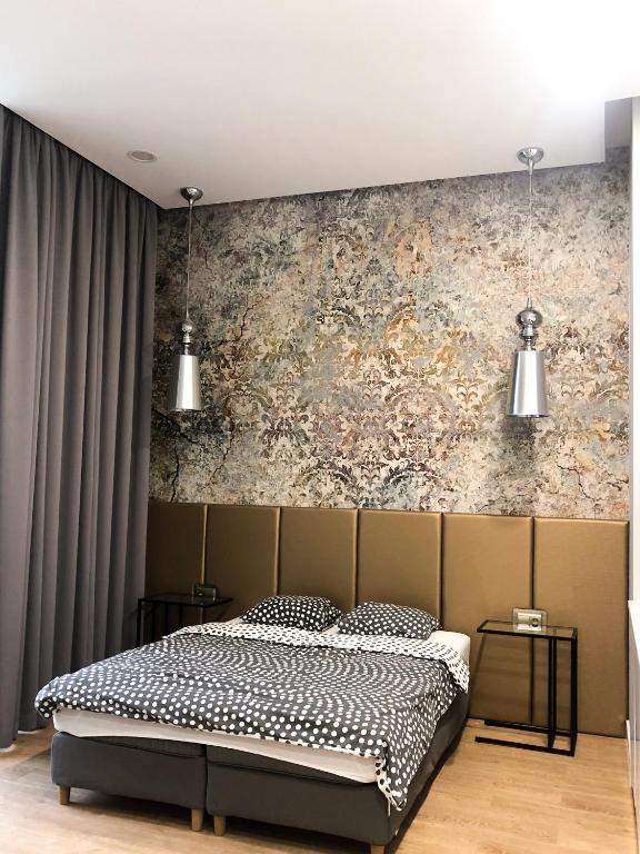 a bedroom with a bed and a wall at Absynt Hostel Wrocław in Wrocław