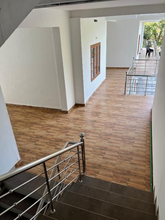 an empty room with stairs and a dog in the distance at Wayanad Biriyomz Residency, Kalpatta, Low Cost Rooms and Deluxe Apartment in Kalpetta