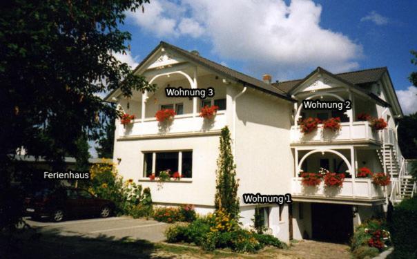 een wit huis met woorden erop bij Ferienwohnungen Beyer in Binz