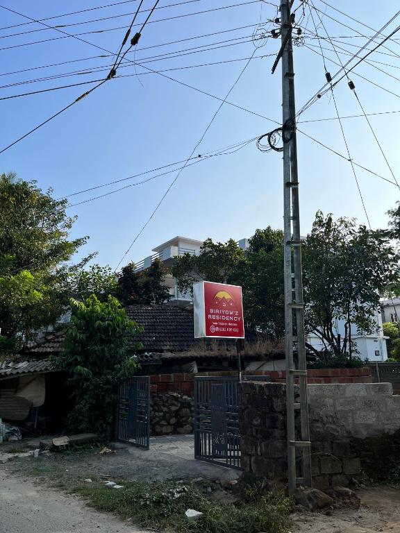 a sign on a pole next to a building at Wayanad Biriyomz Residency, Kalpatta, Low Cost Rooms and Deluxe Apartment in Kalpetta