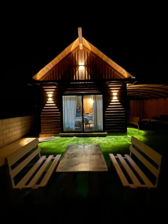 a house with two chairs in front of it at night at בקתת החרמון in Mas'ada