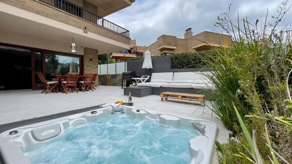 een achtertuin met een hot tub op een patio bij Residencial Bella Donna Lux House, Jacuzzi y piscina privada in Lloret de Mar