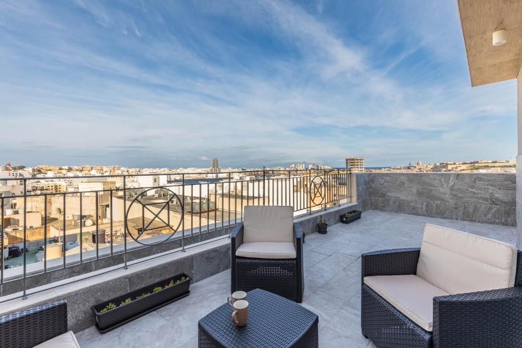 a balcony with furniture and a view of the city at Terrace View - Stylish Two Bedroom Penthouse in Msida