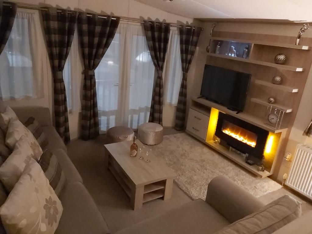 a living room with a couch and a fireplace at 180 Golden Gate North Wales in Abergele