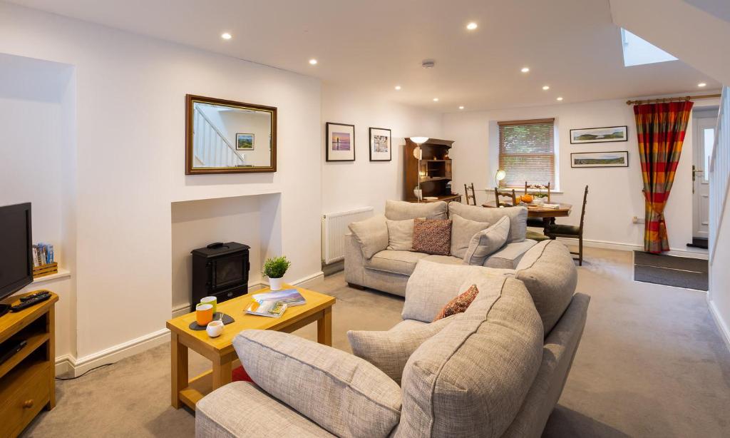 a living room with two couches and a tv at Fern Cottage in Ambleside