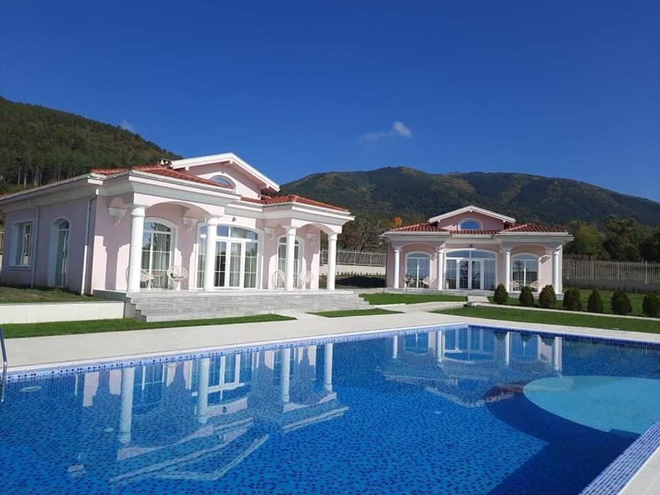 a large house with a swimming pool in front of it at Diamond Villas in Enina