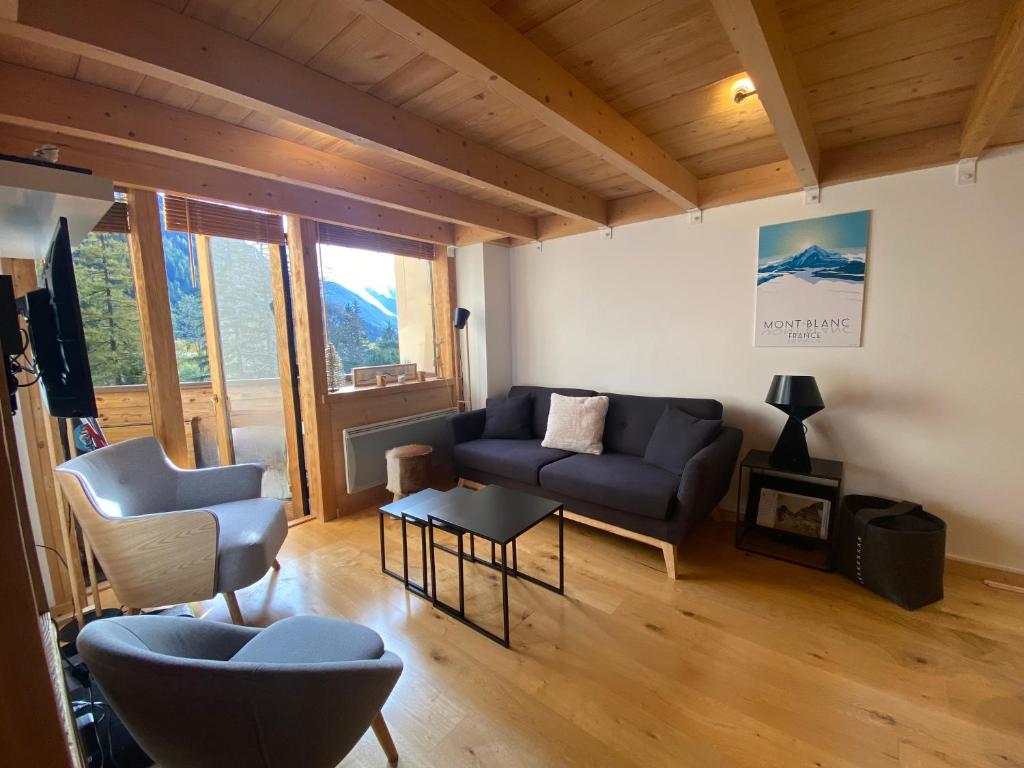 a living room with a blue couch and two chairs at Residence Grand Roc - Kercham in Chamonix-Mont-Blanc