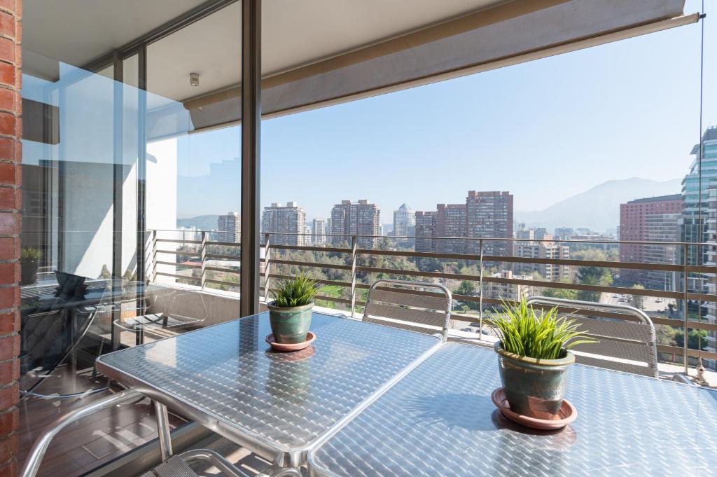 a table with two potted plants on a balcony at Century View 2B W/Balcony, View & Parking. in Santiago
