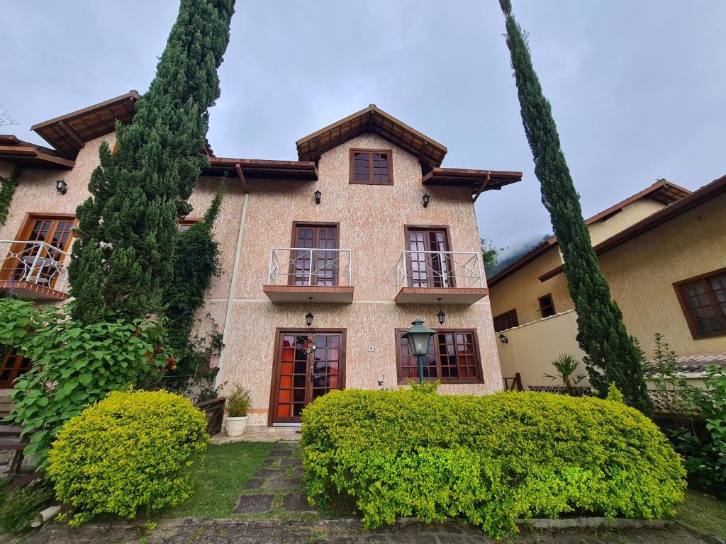 a large house with bushes in front of it at Aconchego da Serra in Teresópolis