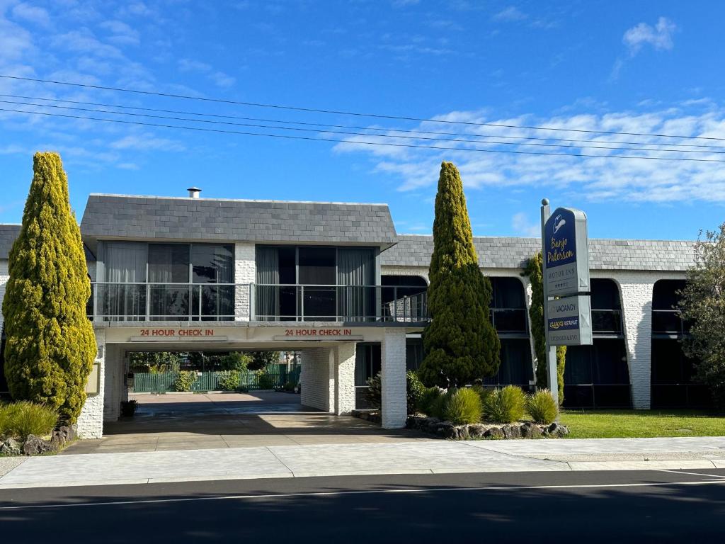 a house with a balcony on a street at Banjo Paterson Motor Inn in Lakes Entrance