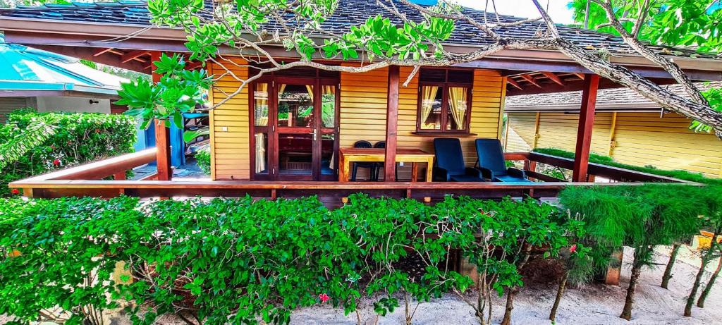 a house with a table and chairs in front of it at MOOREA - The Golden Reef Bungalow Moorea in Temae