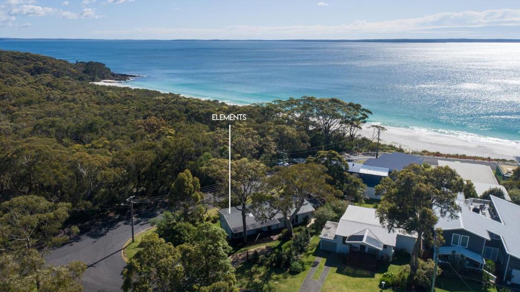 an aerial view of the shoreline of a house and the ocean at Elements of Hyams in Hyams Beach