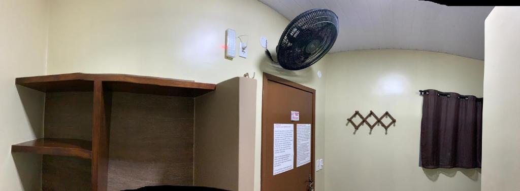 una camera con ventilatore appesa al muro di CASA MEUS AMIGOS KITESURF in the center of Cumbuco a Cumbuco