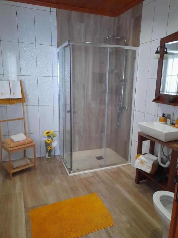 a bathroom with a shower and a sink at Refúgio das Pedreiras in Praia da Vitória