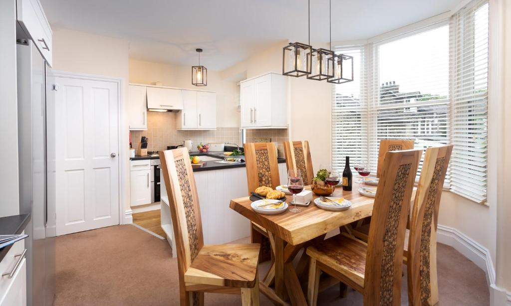 Una cocina y un comedor con mesa y sillas de madera. en Lingmell House, en Windermere