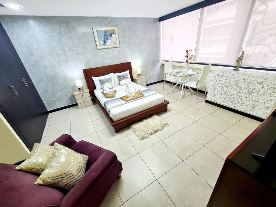 1 dormitorio con 1 cama y 1 sofá en una habitación en Habitacion Matrimonial Vista Rio junto Wyndham, en Guayaquil