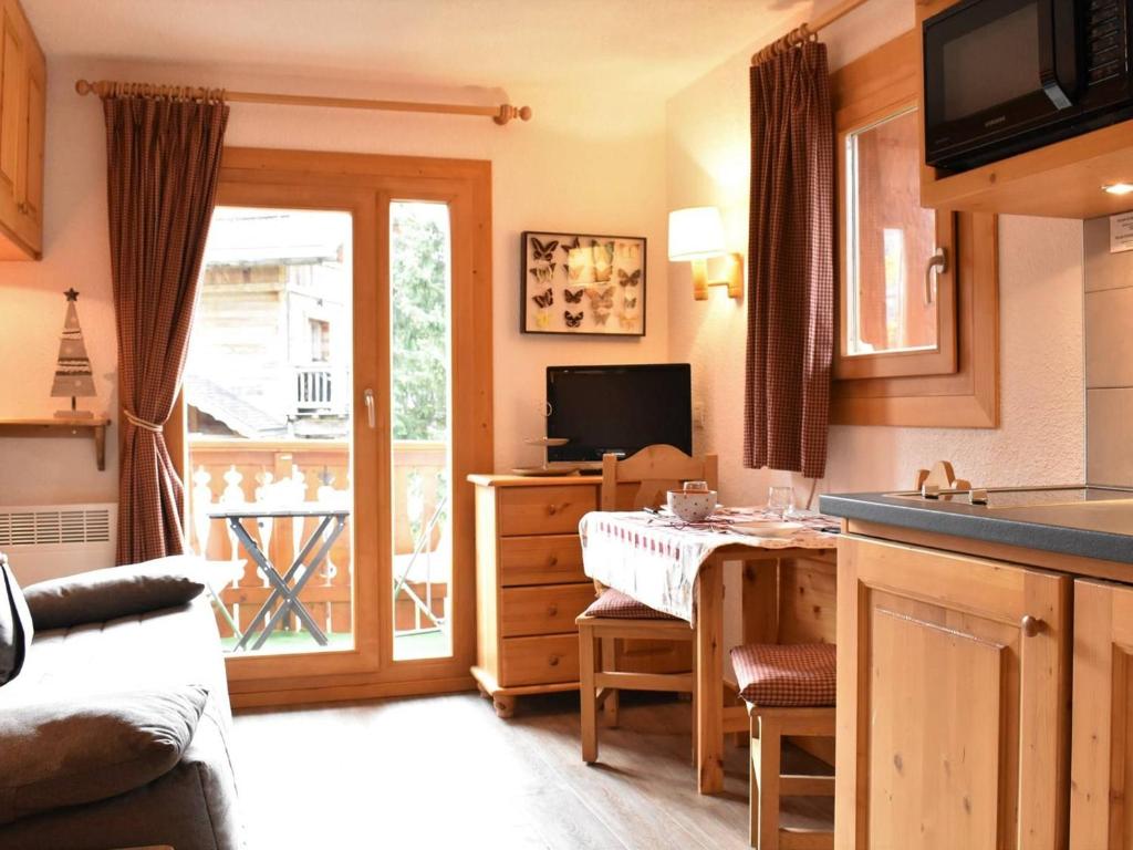 un salon avec une table et une cuisine dans l'établissement Charmant Studio Rénové pour 3 Personnes à Méribel, Proche Pistes et Commerces, Balcon Sud - FR-1-180-33, à Méribel