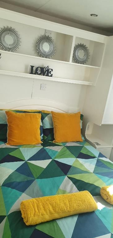 a bedroom with a bed with orange pillows at The Hummingbird in Clitheroe