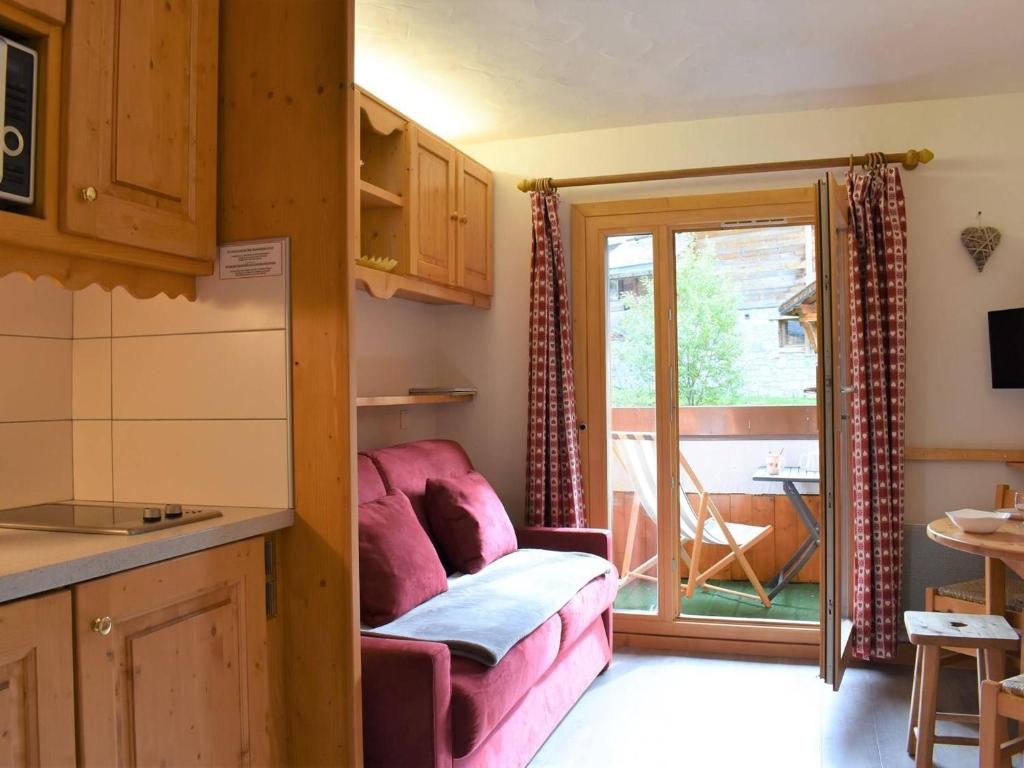 - un salon avec un canapé rose devant une porte dans l'établissement Studio rénové au pied des pistes, balcon sud, 3 pers., Méribel - FR-1-180-32, à Méribel