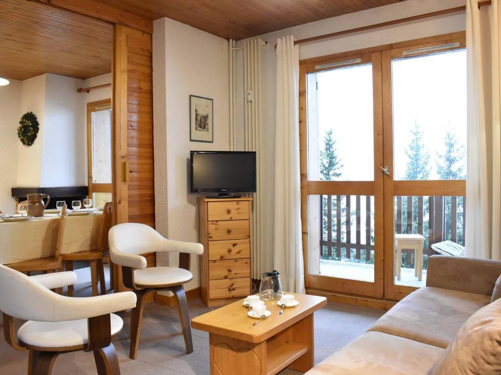 ein Wohnzimmer mit einem Sofa, einem Schreibtisch und einem TV in der Unterkunft Appartement Méribel, 2 pièces, 6 personnes - FR-1-180-66 in Méribel