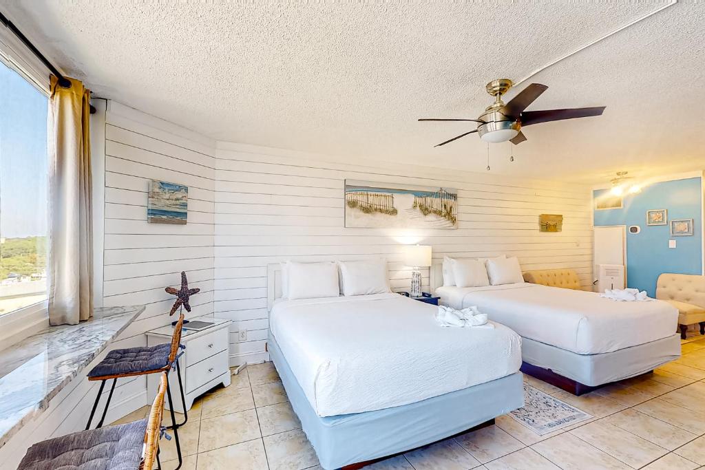 a bedroom with two beds and a ceiling fan at Top of the Gulf 702 Teal Waters in Panama City Beach