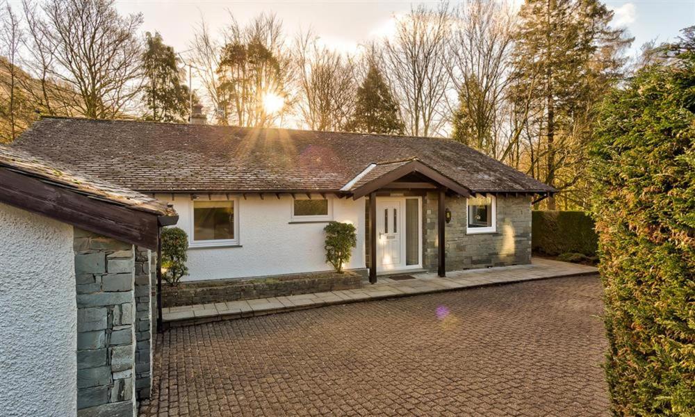 a small white house with a brick driveway at Lanterns At Grasmere in Grasmere