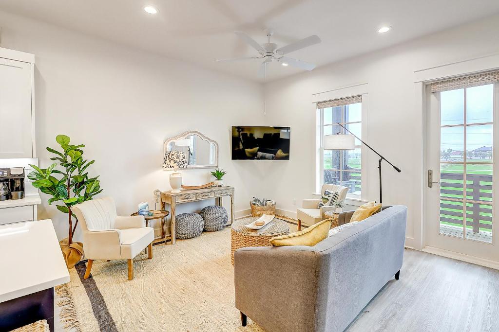 a living room with a couch and chairs and windows at Fairway Sunsets in Port Aransas