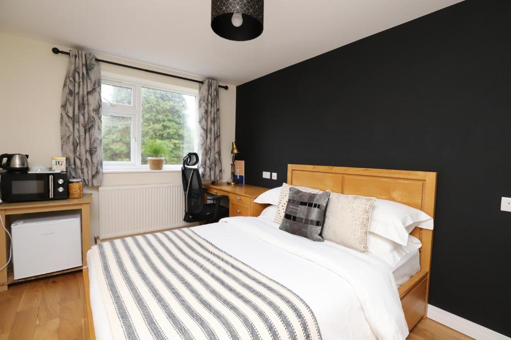 a bedroom with a bed with a black wall at Luxurious double bedroom, ensuite with free Wifi. in Oxford