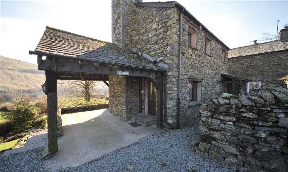 un edificio in pietra con un arco davanti di Butt Hill Cottage a Troutbeck