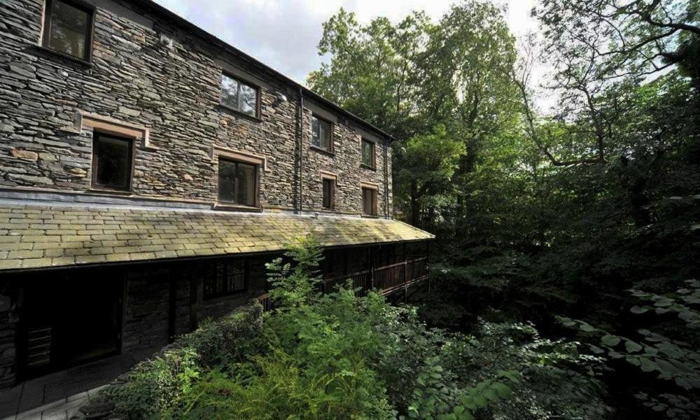 an old brick building with trees in front of it at River Falls View in Ambleside