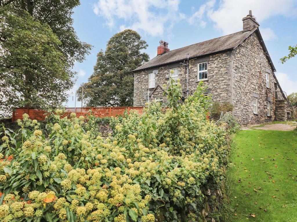an old stone house with a garden in front of it at Raisthwaite Farm in Broughton in Furness