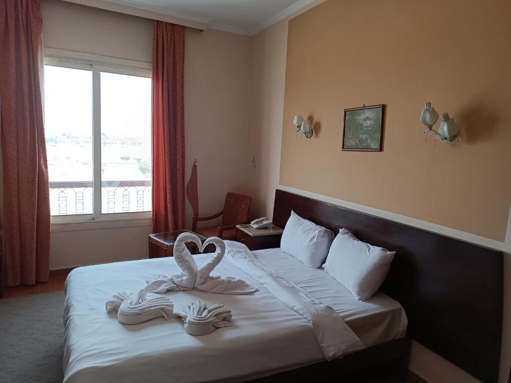 um quarto de hotel com uma cama com toalhas em Susanna Hotel Luxor em Luxor