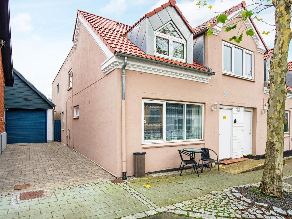 Nørre Snede的住宿－Holiday home Nørre Snede，粉红色的房子,前面有一张桌子