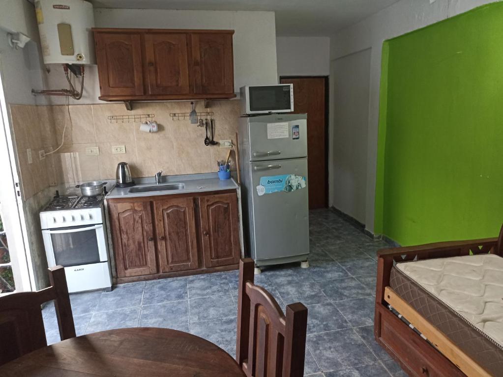 uma cozinha com um lavatório, um frigorífico e uma mesa em Departamentos Temporarios Aeropuerto em Formosa