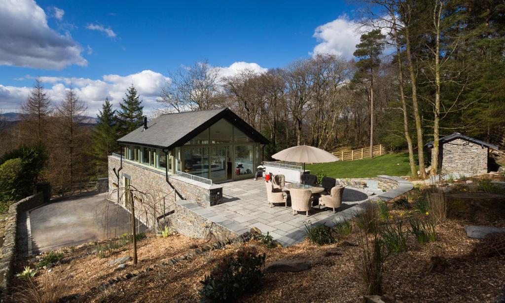 a house with a patio and a building at Tall Trees in Bowness-on-Windermere