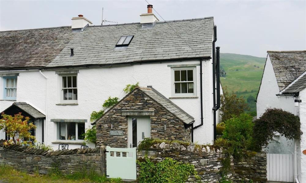 a white house with a stone wall at Church View At Troutbeck in Windermere