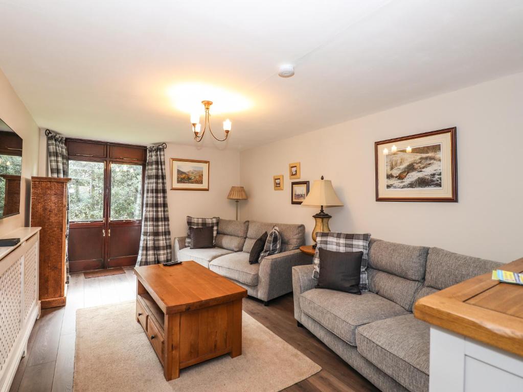 a living room with a couch and a table at Candleberry Cottage in Ambleside