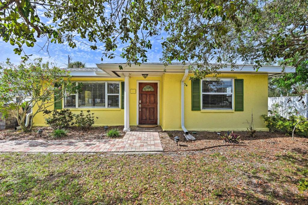 a yellow house with a door and a tree at Nokomis Home with Gas Grill 2 Blocks to Beach! in Nokomis