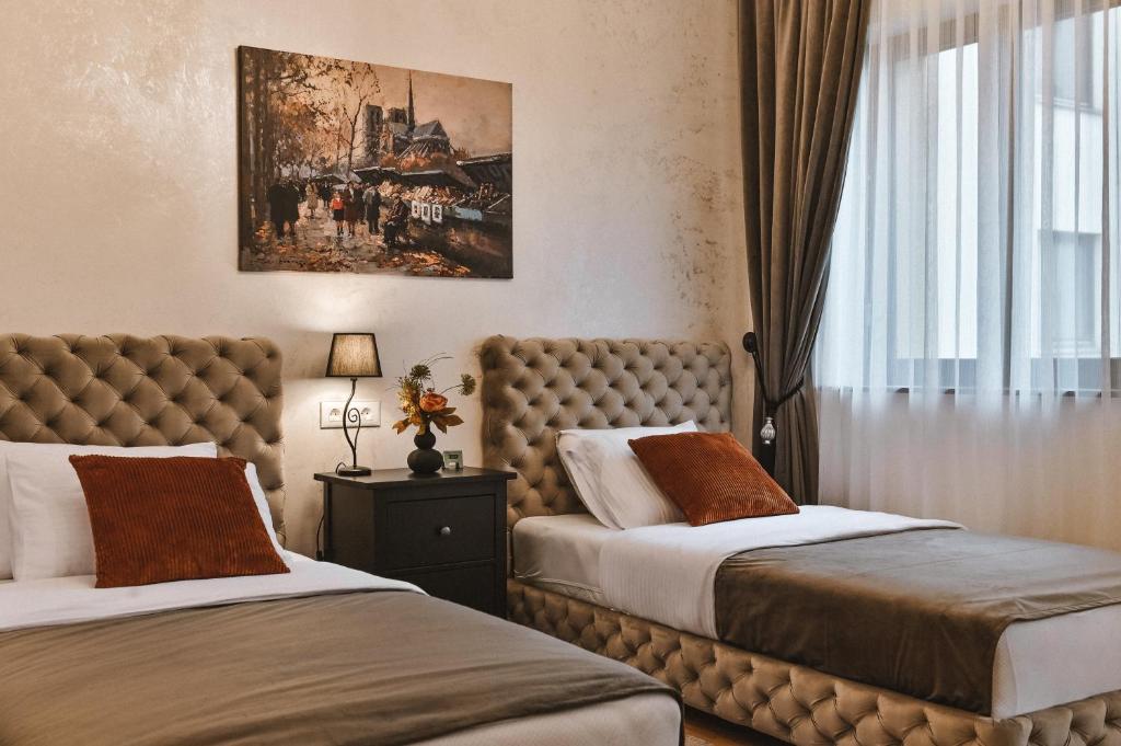 um quarto de hotel com duas camas e uma janela em Garni hotel BARUT em Šabac