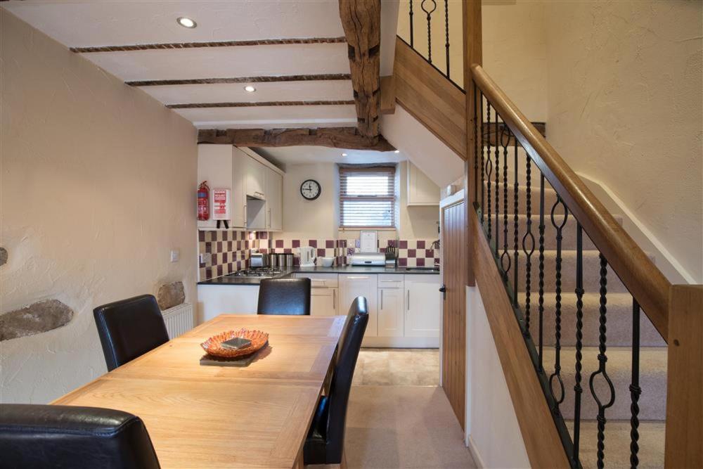a kitchen and dining room with a wooden table and chairs at Penny Red Cottage in Ambleside