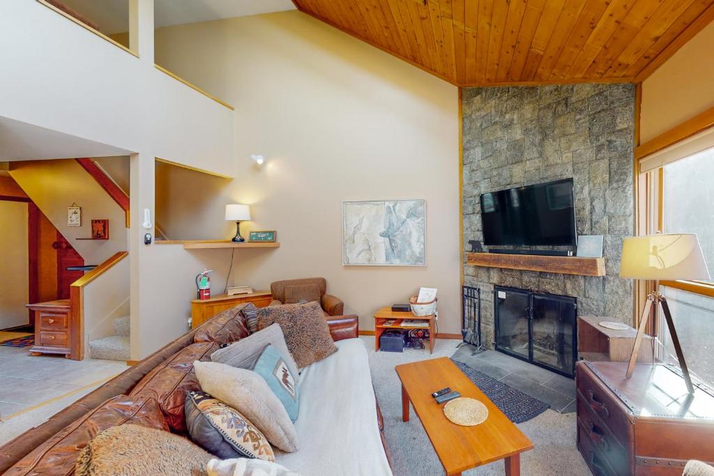 a living room with a couch and a fireplace at Cozy Modern Comfort in Killington