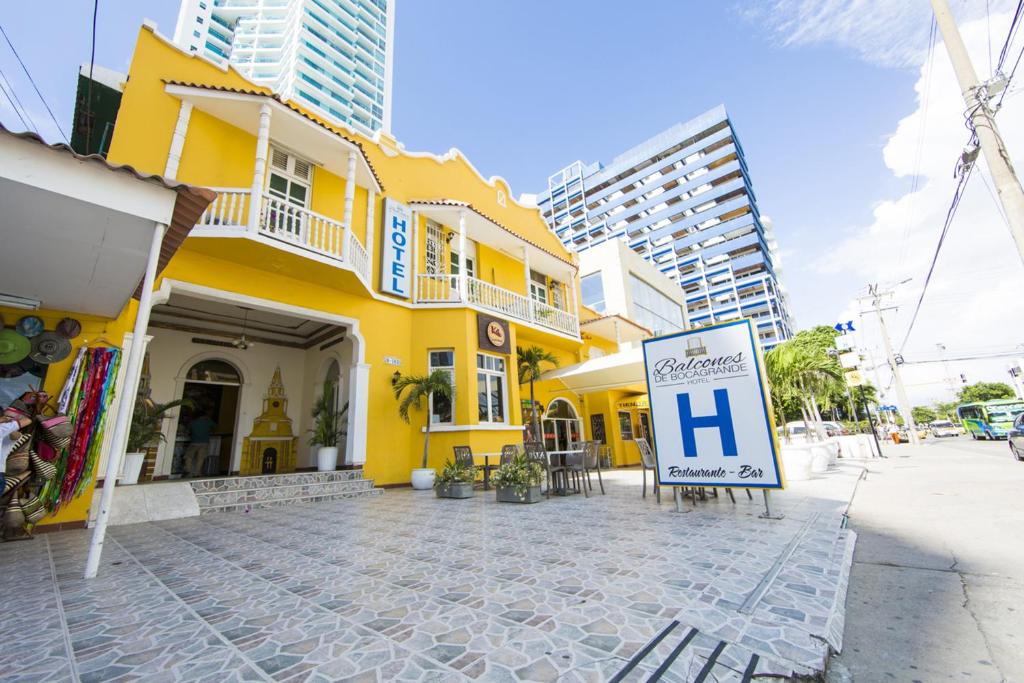 a yellow building with a sign in front of it at Hotel Balcones de Bocagrande in Cartagena de Indias