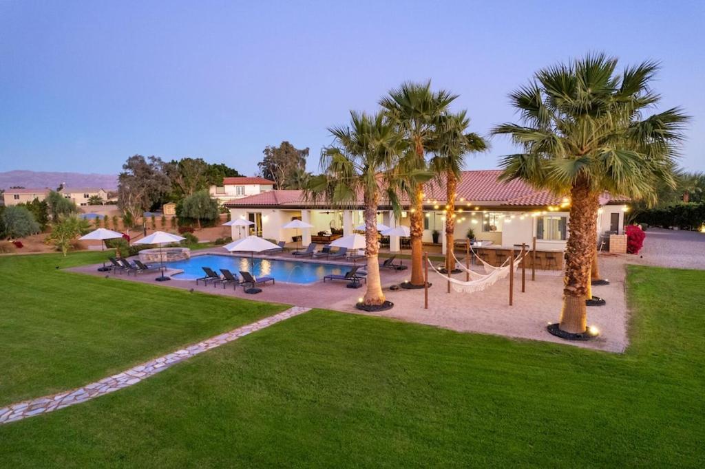 a resort with a hammock and palm trees and a pool at Santal Estate - Play, Relax, Walk to the Festivals in Indio
