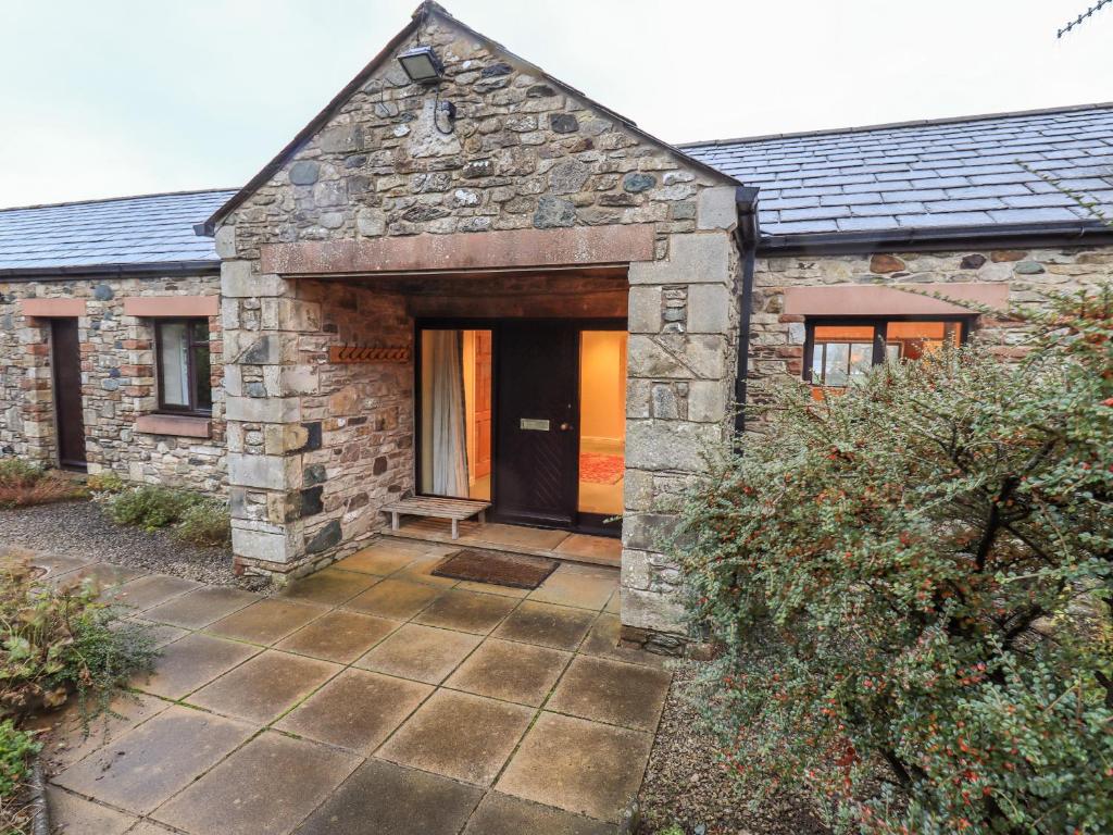 an entrance to a stone house with a black door at Low House in Penrith