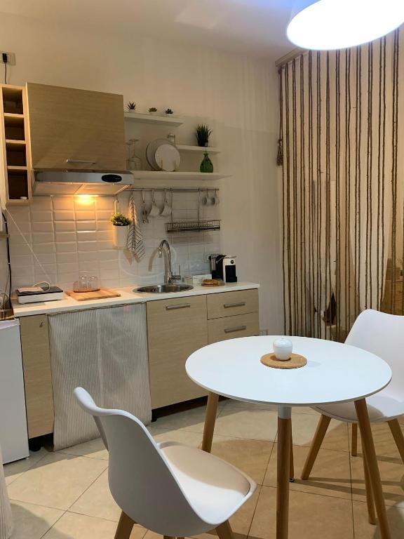 cocina con mesa blanca y sillas en Macadà en Bari