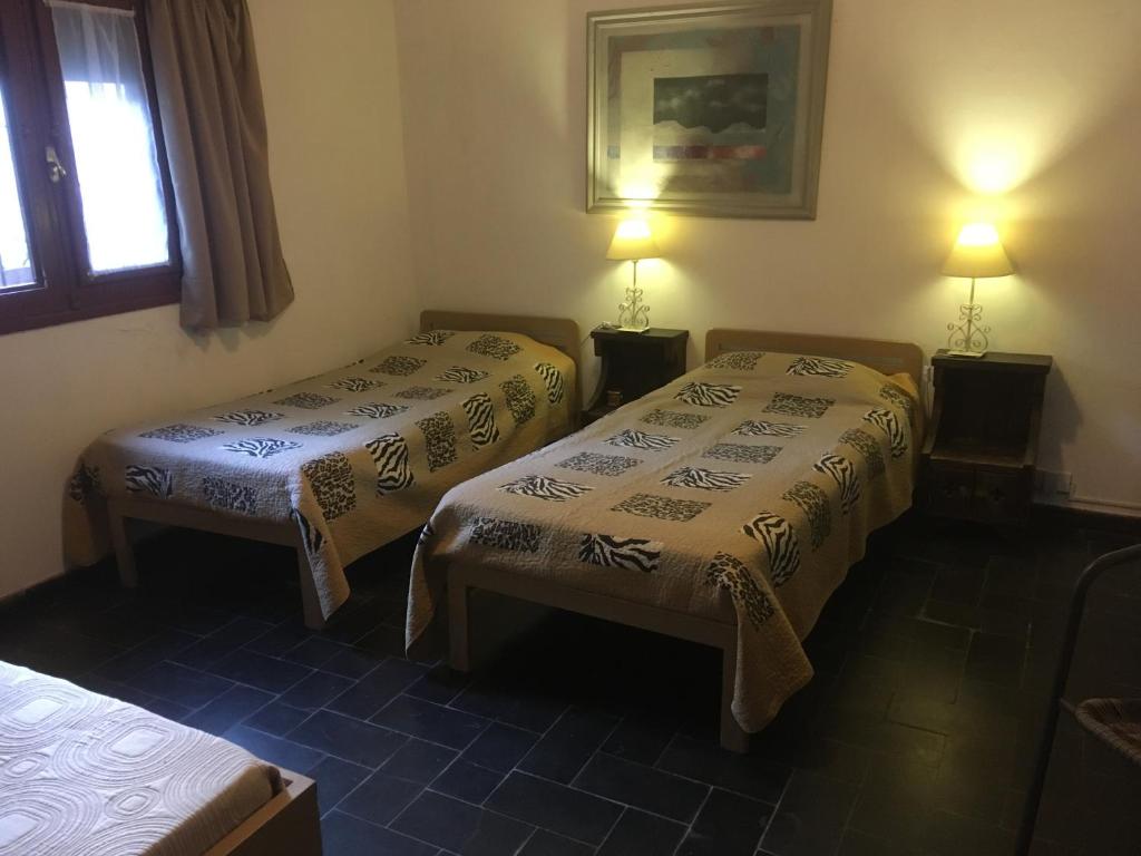 Habitación con 2 camas, 2 lámparas y una ventana en La Fortaleza, en Punta del Este