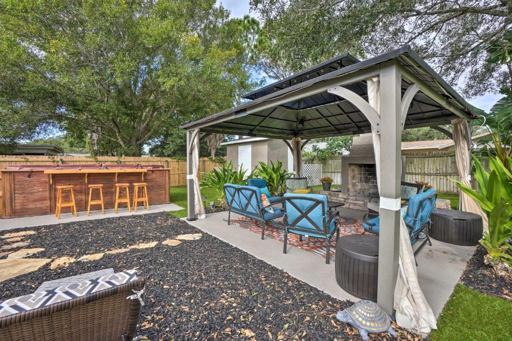 a gazebo with chairs and a table in a yard at Beachy Palm Harbor Escape Swim Spa Pool and Gazebo in Palm Harbor