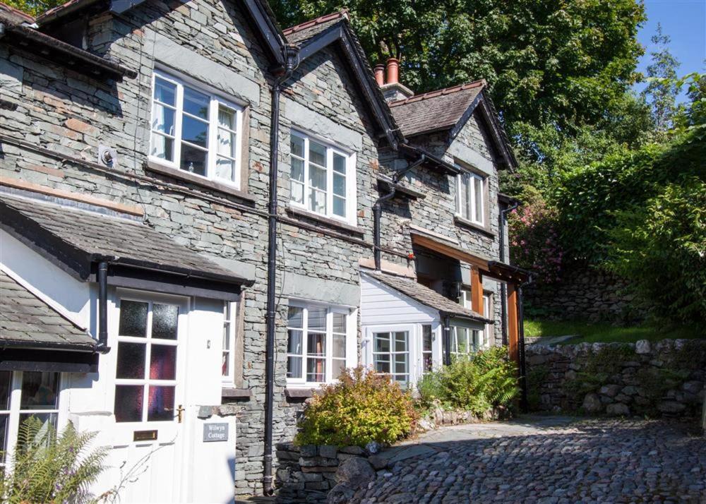 an old stone house with white doors and windows at Briardale Cottage in Ambleside