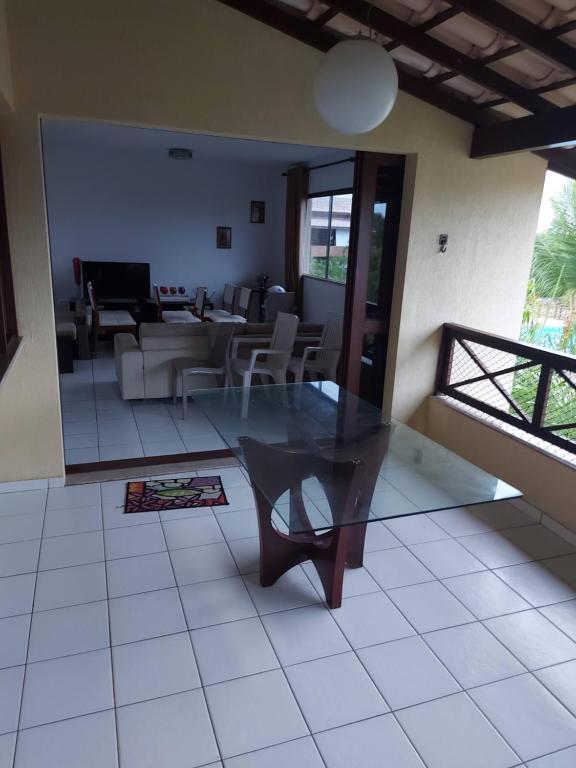 uma sala de estar com uma mesa de vidro e um sofá em Apartamento em guarajuba 200m da praia em Camaçari